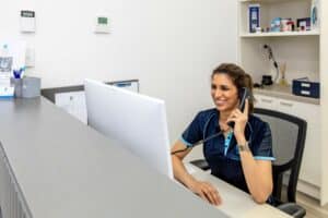 Receptionist speaking on phone at physiotherapy centre